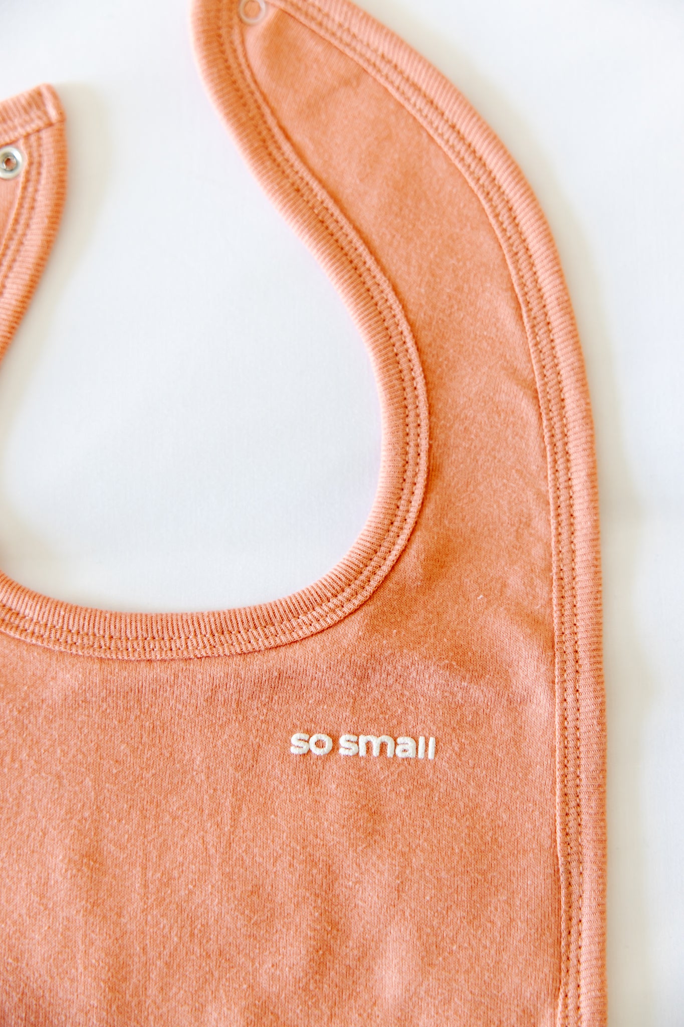 so small Organic Terry Lined Bib- Peach & Cream