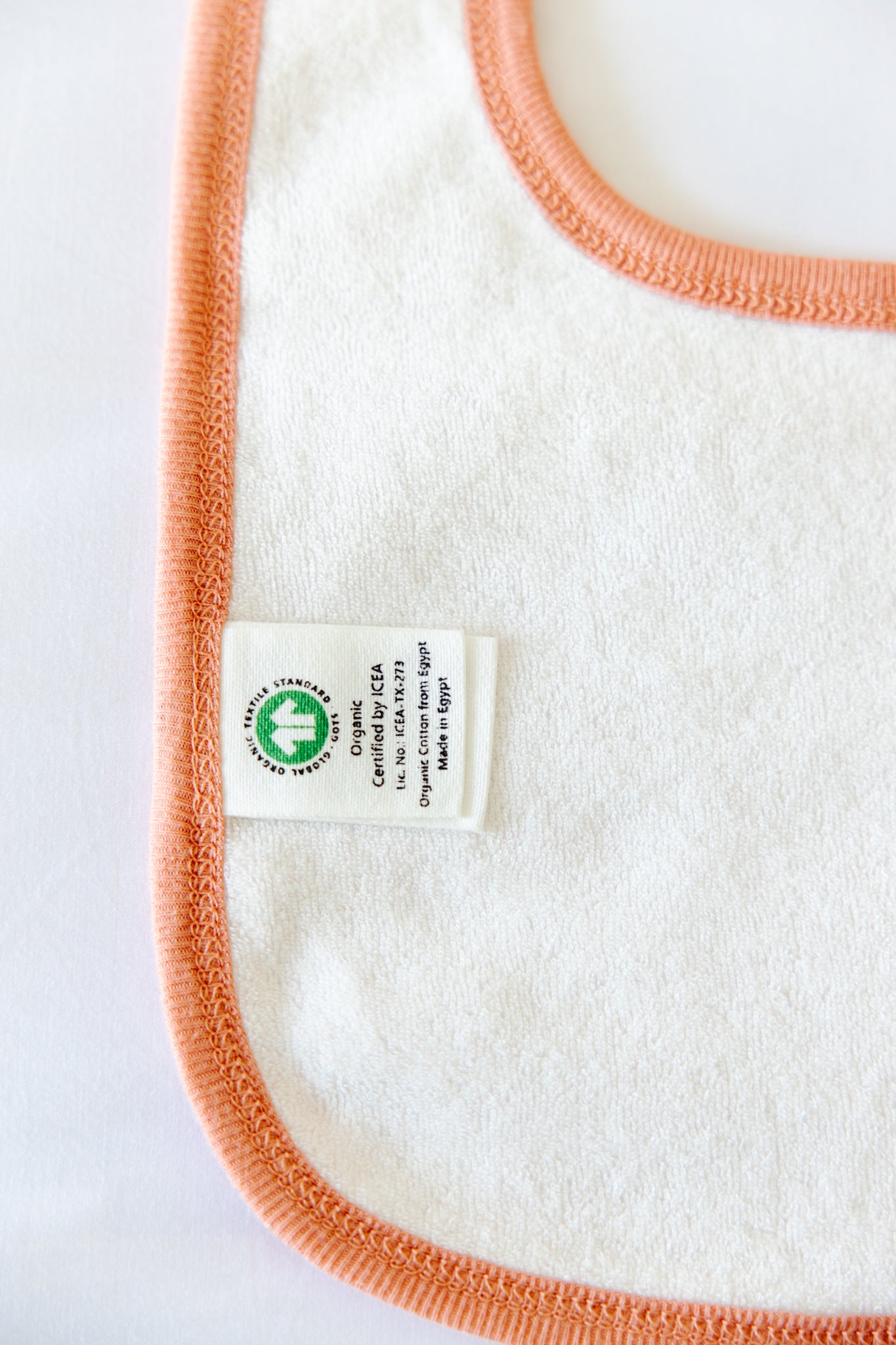 so small Organic Terry Lined Bib- Peach & Cream